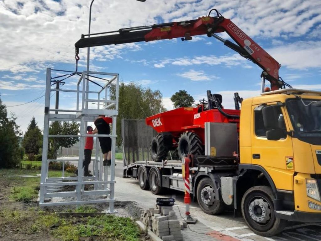 Nákladní automobil Volvo FM 370 instalující pomocí hydraulické ruky kovovou konstrukci