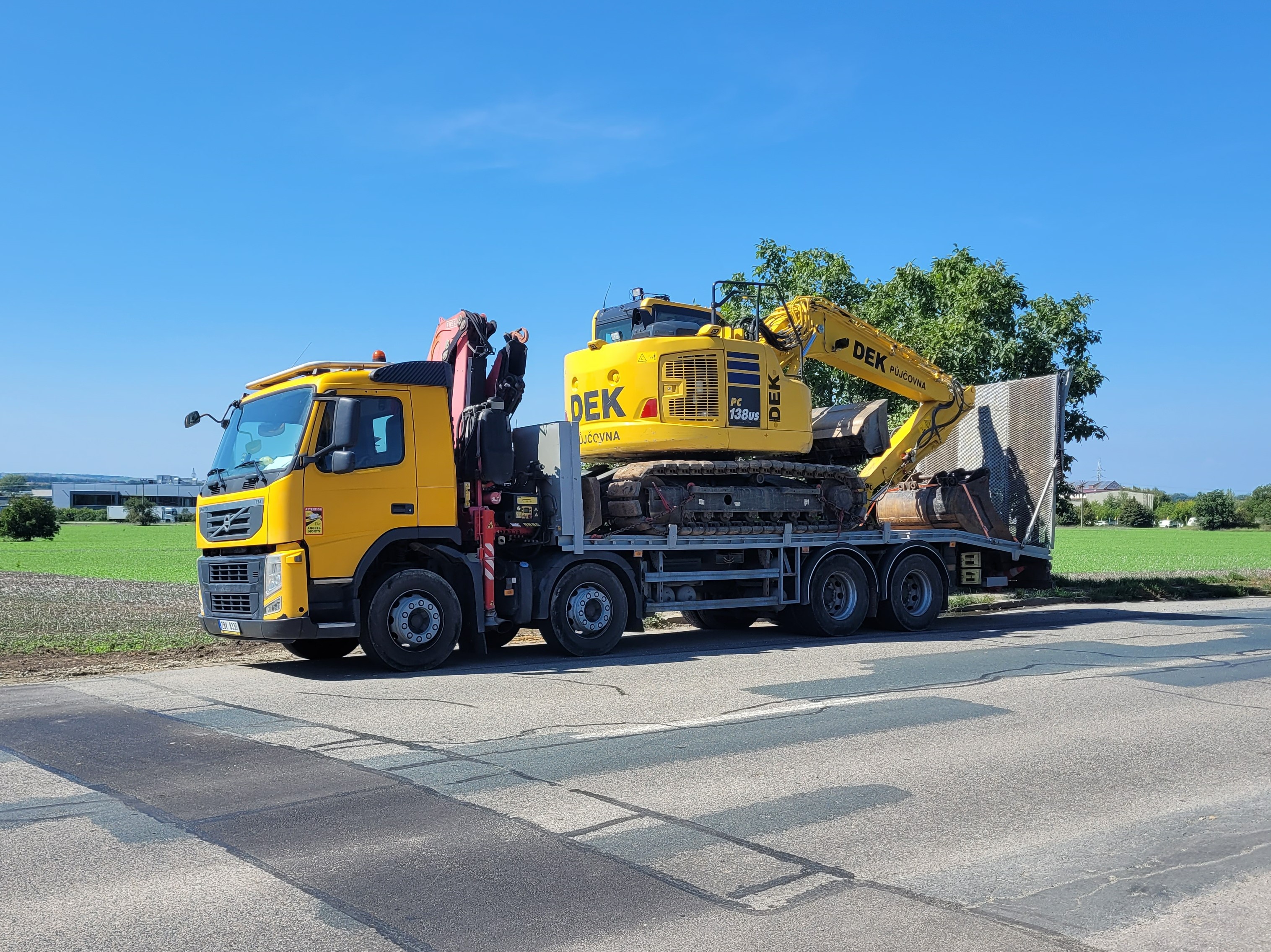 Přepravní speciál Volvo FM 370 s naloženým stavebním strojem